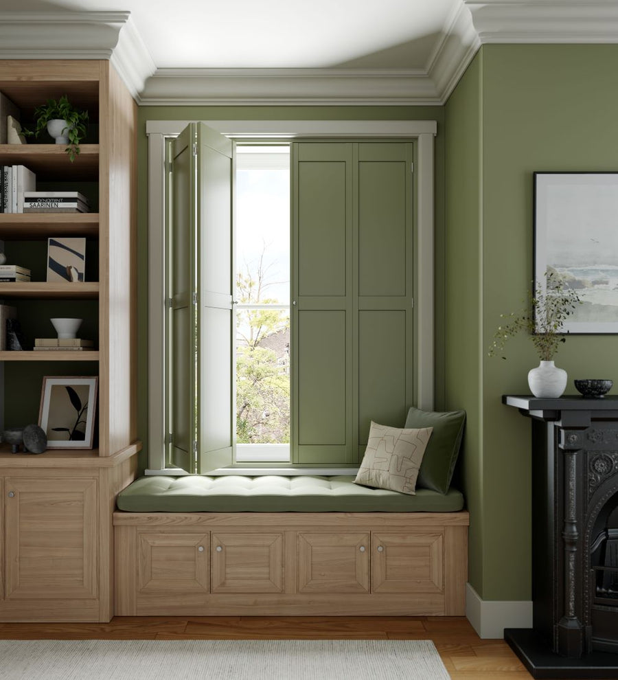 green solid shutters in the same colour as the wall, with window bench with green cushion