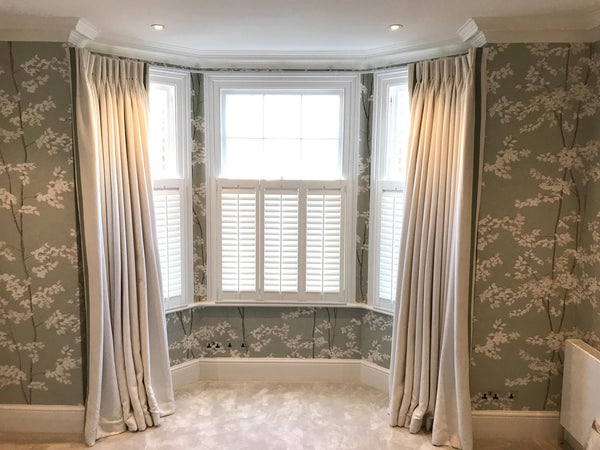 bay window with cafe style bay window shutters in a room with floral wall paper