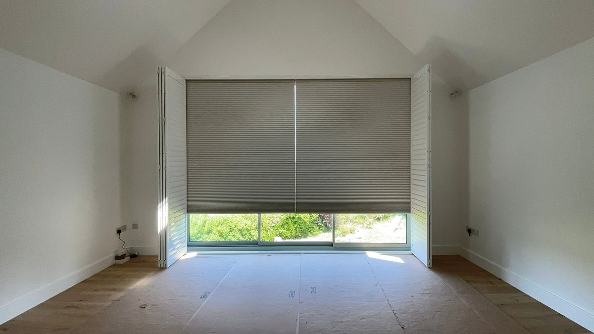 Motorised honeycomb blinds behind tracked shutters in the Banbury farmhouse