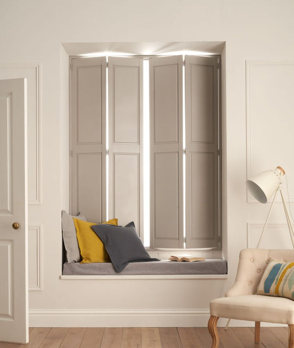 grey solid shutters in a window alcove, with grey cushion