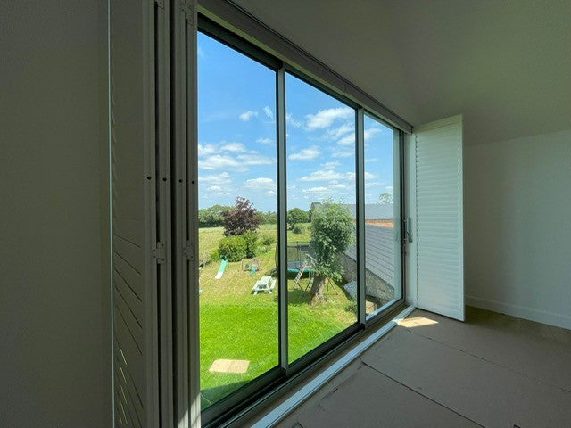 Tracked bi-fold Fiji hardwood shutters on a large Banbury farmhouse bedroom window