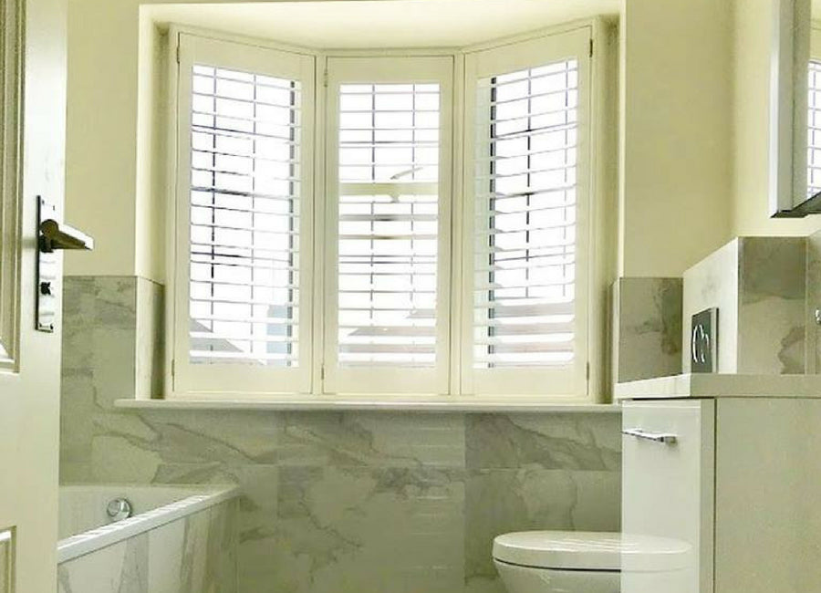 White bathroom shutters showing the louvre proportions and window architecture
