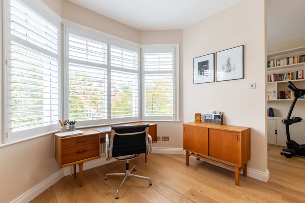 wooden shutters on a large window in a room corner used as a studio